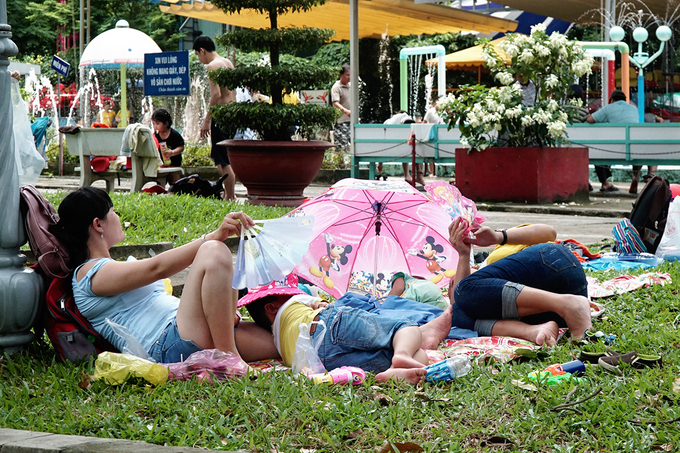 Du khách trải áo mưa, ngủ la liệt trong công viên Sài Gòn